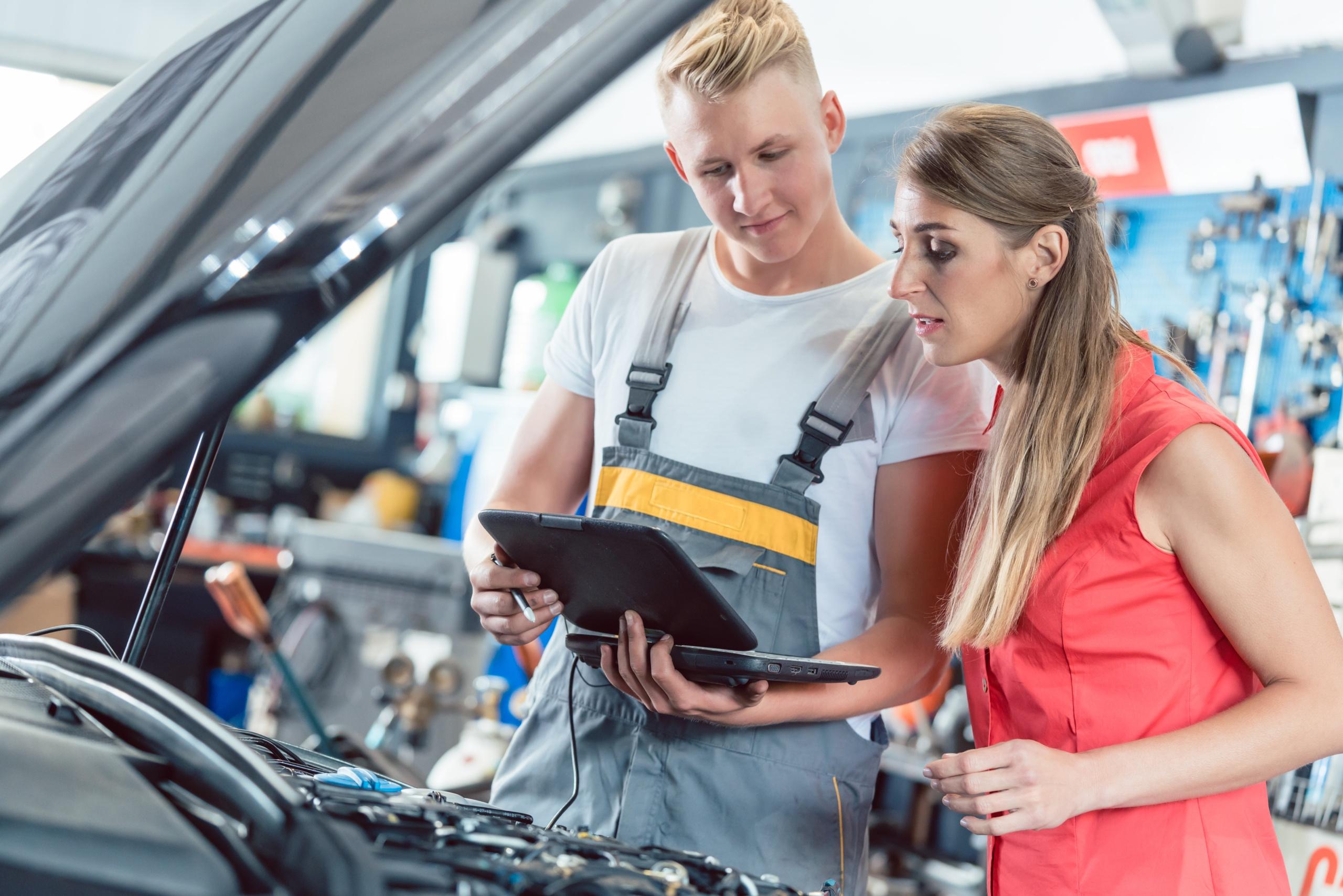 Auto mechanic showing to a customer the engine error codes